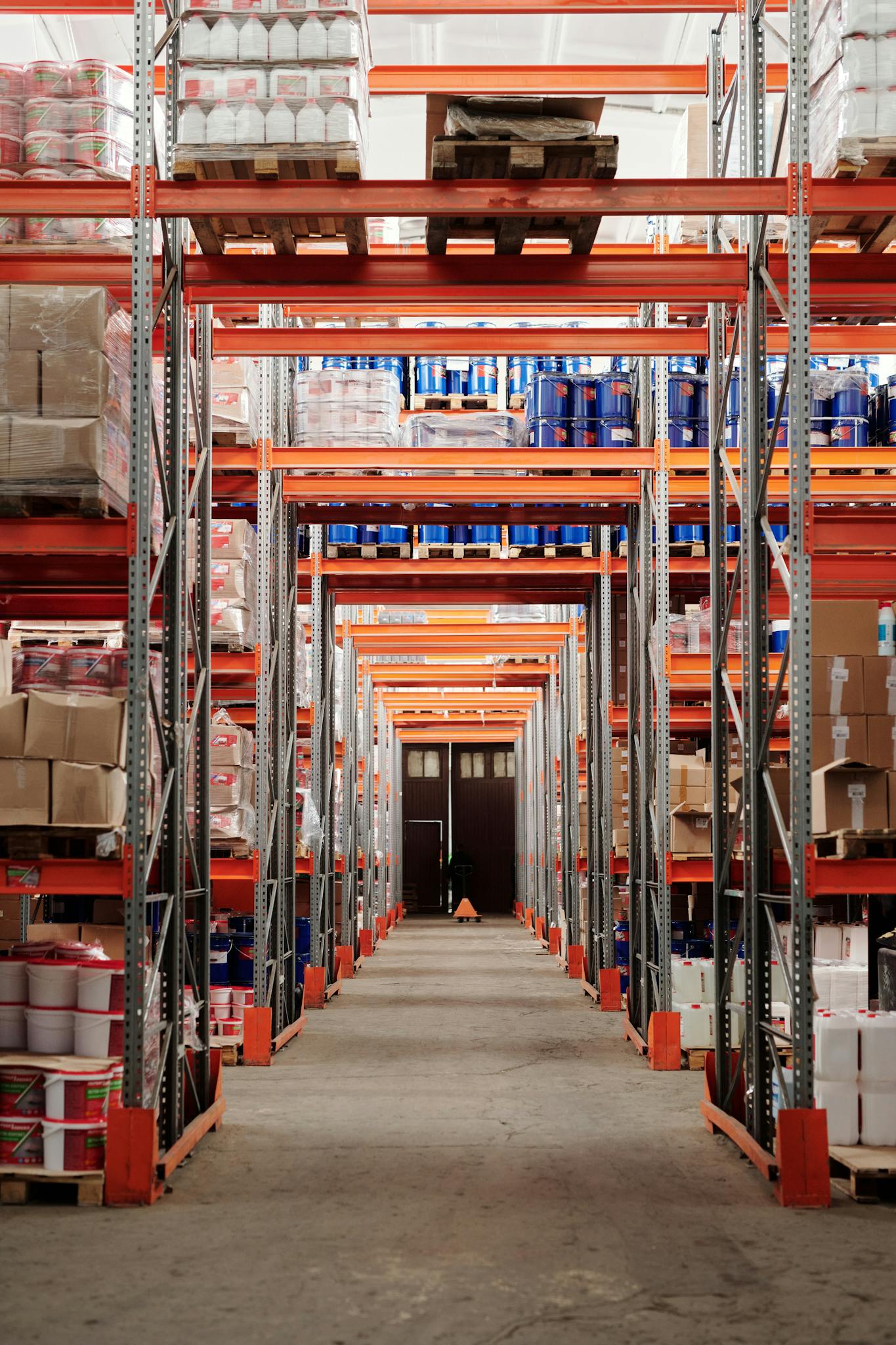 A modern warehouse interior showcasing organized shelves and pallets for efficient storage.